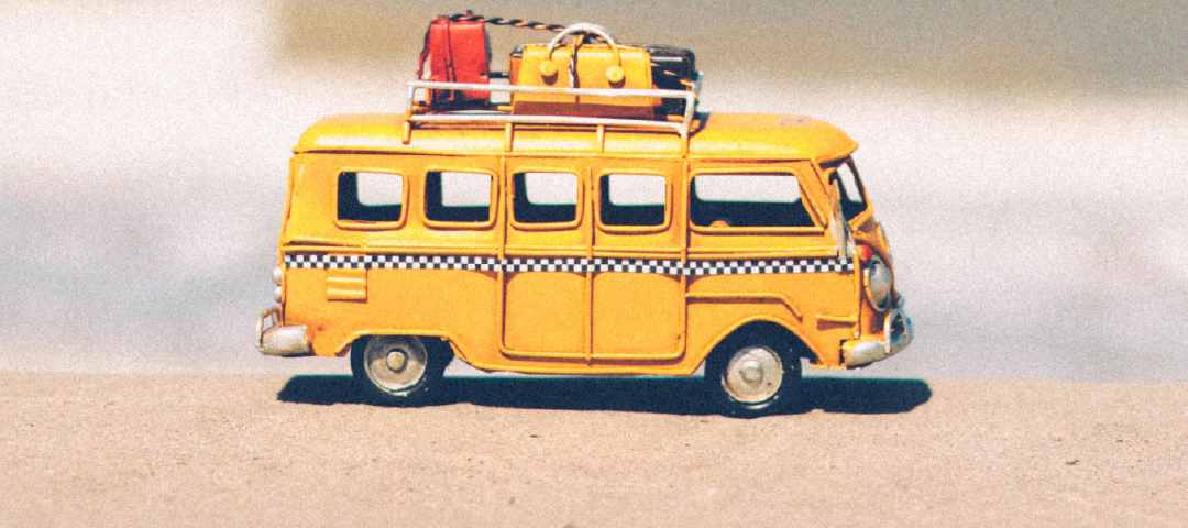 Gul minibuss med packning på taket.